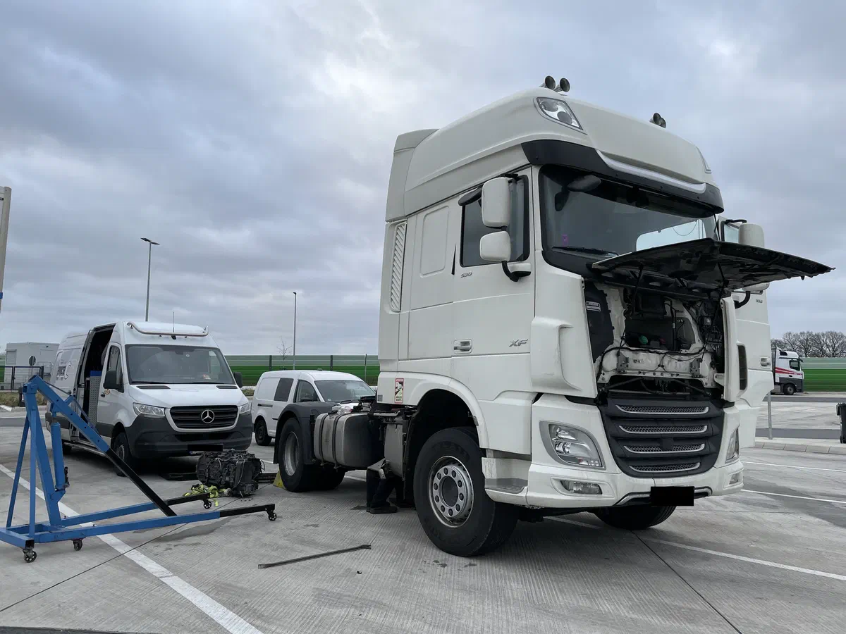 Our service van and engine hoist next to a DAF truck during a repair in a parking area